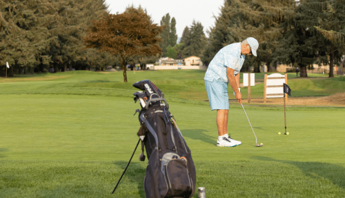 A man tees up on a verdant golf course