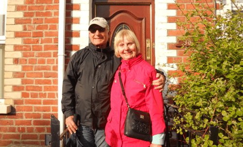 Tom and Pat Barte in front of a brick building